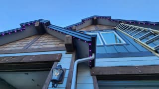 Permanent LED lights in purple on a craftsman home
