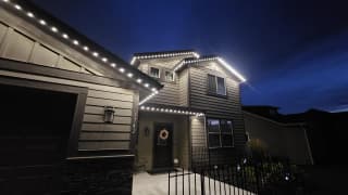 Home outlined in warm white permanent LED roofline lighting at night