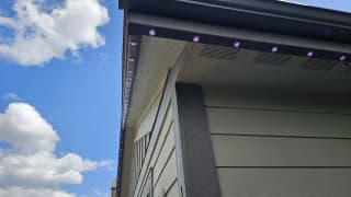 RGBW puck lights installed in black aluminum track under an eave